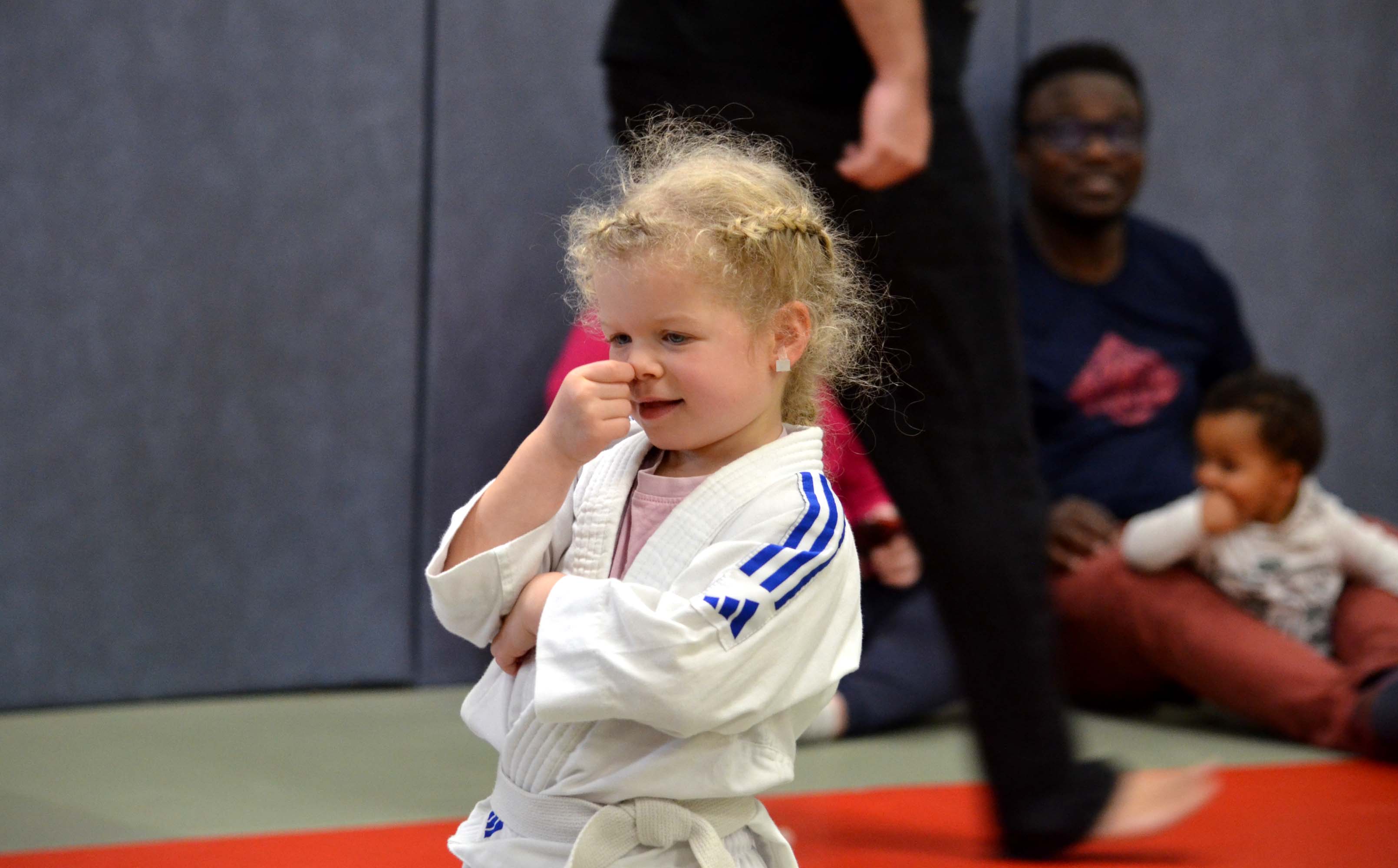 Petite fille en judogi, poing levé, après un cours de baby judo